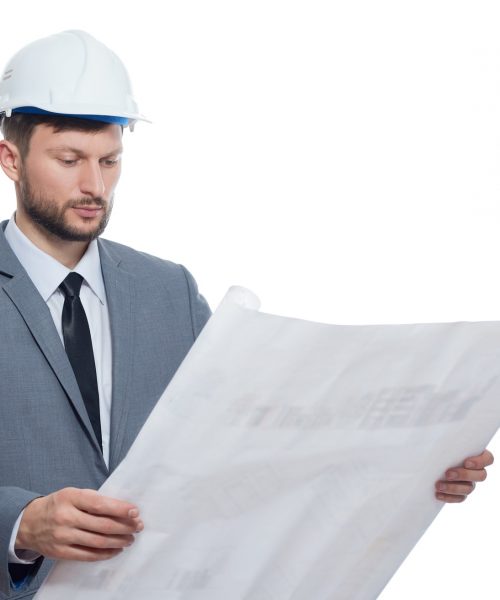 Engineer in safety hat reading architecture plan