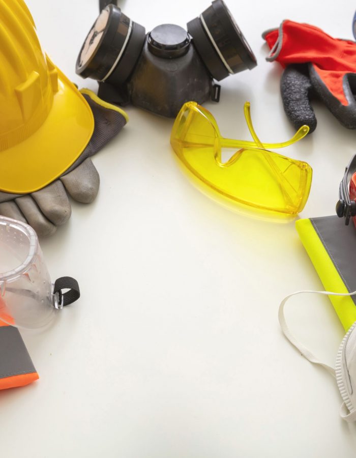 Work safety protection equipment flat lay. Industrial protective gear on white background, closeup view. Construction site health and safety concept